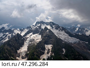View of the Dzhuguturluchat mountain range of the Great Caucasus Range from the upper station of the cable car of the Dombay ski resort on a summer day, Karachay-Cherkessia, Russia. Стоковое фото, фотограф Ula Ulachka / Фотобанк Лори