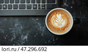 Warm Cup of Coffee With Latte Art on a Textured Surface Beside Notebooks and a Sketchpad. Стоковое AI-изображение, AI-художник Юлия Гапеенко / Фотобанк Лори