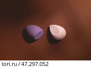 Cosmetics makeup sponges on a dark brown background with shadows. Стоковое фото, фотограф Юлия Трикашная / Фотобанк Лори