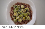 A delicious Quinoa and Brussels Sprouts Bowl filled with an array of fresh green veggies. Стоковое видео, видеограф Vladimir Vintonjak / Фотобанк Лори