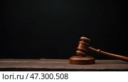 A Wooden Gavel Rests on a Rustic Table in a Dimly Lit Courtroom, Symbolizing Justice and Legal Proceedings. Стоковое AI-изображение, AI-художник Sergey Grishin / Фотобанк Лори