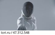 Fencing - young woman fencer in white suit puts on her protective helmet and aiming in the camera with a sword. Стоковое видео, видеограф Константин Шишкин / Фотобанк Лори
