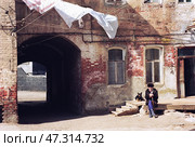 Старый Астраханский проходной двор, мужчина , пенсионного возраста, рядом верный друг-собака, деревянные ступени, арка. Редакционное фото, фотограф Павел Просянов / Фотобанк Лори