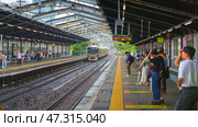 Osaka, Japan - Sep 22 2024, Panoramic view of the railway ground station where the electric train arrives, there are a lot of people on the platform, at daytime, Osaka, Japan. Редакционное фото, фотограф Сергей Богомяко / Фотобанк Лори