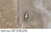 A large construction vehicle is driving through a sandy area. Стоковое видео, видеограф Скрипачев Антон / Фотобанк Лори