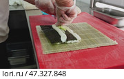 Skillful sushi preparation at a bustling kitchen in Tokyo using fresh ingredients and traditional techniques with attention to detail. Стоковое видео, видеограф Сергей Толмачёв / Фотобанк Лори