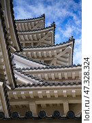 Himeji, Japan - Sep 24 2024, vertical, a view from bellow of the corners of multi-level roofs of Himeji Castle, the White Heron Castle, with a cloudy sky on background, without people, Himeji, Japan. Стоковое фото, фотограф Сергей Богомяко / Фотобанк Лори