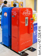 Osaka, Japan - Sep 25 2024, vertical, A close-up view of two antique soda machines, blue and red, Coca-Cola and Pepsi-Cola companies, in a shopping mall on Osaka Umeda, without people, Osaka, Japan. Редакционное фото, фотограф Сергей Богомяко / Фотобанк Лори