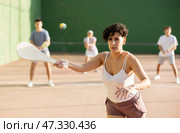 Active womans with enthusiasm playing paleta fronton group on outdoor court. Стоковое фото, фотограф Яков Филимонов / Фотобанк Лори
