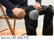 Builder man wearing protective knee pads on the legs. work safety protection equipment. Стоковое фото, фотограф Сергей Чуйко / Фотобанк Лори