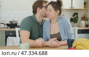 Loving mature couple interactions at home. Husband and wife hugging, holding hands and drinking morning coffee together. Man and woman talk about plans for weekend. Natural lighting. Intimate moments. Стоковое видео, видеограф Марина Демидюк / Фотобанк Лори