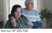 Old couple have breakfast sitting at the kitchen table, drink coffee. Embracing elderly man and woman. Senior couple together marriage in retirement talking with each other. Enjoying the pleasantries. Стоковое видео, видеограф Марина Демидюк / Фотобанк Лори