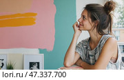 Young artist smiling and looking away in art studio. Стоковое AI-видео, аниматор Юрий Поздников / Фотобанк Лори