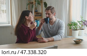 Loving mature couple interactions at home. Husband and wife hugging, holding hands and drinking morning coffee together. Man and woman talk about plans for weekend. Natural lighting. Intimate moments. Стоковое видео, видеограф Марина Демидюк / Фотобанк Лори