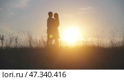 Silhouettes of lovers run to meet each other and the guy is circling his girlfriend. The dog is nearby. Стоковое видео, видеограф Mikhail Davidovich / Фотобанк Лори