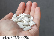 Мужская рука крупным планом протягивает горсть больших белых таблеток. Стоковое фото, фотограф Валерий Елистратов / Фотобанк Лори