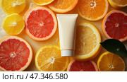 Bright citrus fruits surround a white moisturizer mockup tube product on a vibrant surface. Яркие цитрусовые фрукты окружают белый увлажняющий продукт в макете тюбика на яркой поверхности. Стоковое AI-изображение, AI-художник Katsiaryna Repich / Фотобанк Лори