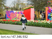 Lisse, Netherlands - April 17, 2019: People,kids and decoration and visitors in a Keukenhof park. Редакционное фото, фотограф Irina Kuchugurina/Gaudy / Фотобанк Лори