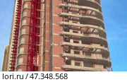 The construction of a multistory building with a prominent red crane is noteworthy. Стоковое видео, видеограф Vladimir Vintonjak / Фотобанк Лори