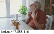 Senior Man shaving his face. Old male shaves beard and mustache with shaver. Elderly gray haired man looking at the mirror, applies shaving cream foam and using razor. Skin hygiene. Daily body care. Стоковое видео, видеограф Марина Демидюк / Фотобанк Лори
