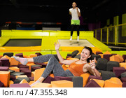 Happy woman jumping into foam cube pit at indoor trampoline park. Стоковое фото, фотограф Яков Филимонов / Фотобанк Лори