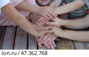 A friendly family joins their hands as a sign of joint success. Стоковое фото, фотограф Mikhail Davidovich / Фотобанк Лори
