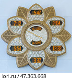 Abu Dhabi, United Arab Emirates - Jan 10 2024, Close-up view of an electronic clock made in the form of lotus flower, on the wall in the Grand Mosque of Sheikh Zayed, Abu Dhabi, United Arab Emirates. Редакционное фото, фотограф Сергей Богомяко / Фотобанк Лори