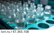 Bottles of Clear Liquid Arranged in a Laboratory Setting With Focus on Scientific Research. Стоковое AI-изображение, AI-художник Sergey Grishin / Фотобанк Лори