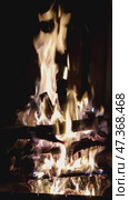 Bright flame of a burning fire. Fire burns over stacked birch and pine firewood. Bright flame of a fire rises high up. Yellow-orange flame tongues wriggle. Стоковое видео, видеограф Andrew_Swarga / Фотобанк Лори