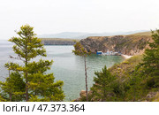 Baikal Lake on hot foggy summer day. Tourists travel on pleasure boat along Small Sea and sail into cozy sandy bay of Olkhon Island for rest and fishing. Summer travels and outdoor recreation. Стоковое фото, фотограф Виктория Катьянова / Фотобанк Лори