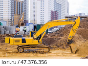 Heavy machinery for excavation and landscaping. Close-up view of an excavator at a construction site. The excavator excavates the soil for excavation and construction. Стоковое фото, фотограф Photojuli / Фотобанк Лори