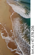 Ocean Waves Gently Crash on Sandy Shore at Sunset Creating a Serene Coastal View in a Tranquil Beach Setting. Стоковое AI-видео, аниматор Оксана Медведева / Фотобанк Лори
