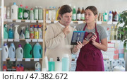 Polite young female sales assistant of personal care department talking friendly and offering options of safety razors to hesitant male customer. Стоковое видео, видеограф Яков Филимонов / Фотобанк Лори
