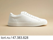 White leather lace-up running shoes with low tops, thick soles on a beige. The laces and rubber outsole. Sporty look. Men to wear during outdoor activities. Street hiking shoes. Trendy Male Boots Pair. Стоковое AI-изображение, AI-художник Марина Демидюк / Фотобанк Лори