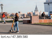 People ride rented scooters on Poklonnaya Gora.Russia, Moscow, 22 April 2023. Редакционное фото, фотограф Photojuli / Фотобанк Лори