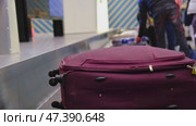 The suitcase goes along the conveyor belt at the airport in the baggage claim area, tourists take their suitcases. Стоковое видео, видеограф Ольга Симонова / Фотобанк Лори