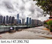 Lantau Island, Hong Kong - April 09, 2024: Skyline of Lantau Island in Hong Kong showcases towering buildings and a serene waterfront promenade. Редакционное фото, фотограф Кривошеина Елена Леонидовна / Фотобанк Лори