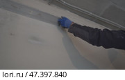 Men's hands in protective gloves with a construction metal rule in their hands align the wall near the ceiling. Home improvement. Apartment renovation. Стоковое видео, видеограф Darya Komarova / Фотобанк Лори
