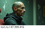 Profile of a Man Sitting in a Dimly Lit Room, Exuding Intensity and Contemplation During a Moment of Reflection or Waiting. Стоковое AI-изображение, AI-художник Sergey Grishin / Фотобанк Лори