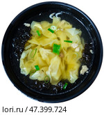 Wonton soup is cooked dumplings filled with meat or seafood. They are served in broth, usually enriched with onions and other ingredients. Chinese cuisine. Стоковое фото, фотограф Яков Филимонов / Фотобанк Лори