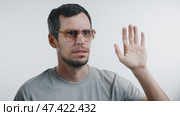 A cheerful man waves, his smile fading as an unexpected sight triggers confusion. Стоковое видео, видеограф Илья Шаматура / Фотобанк Лори