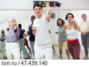 Caucasian man rehearsing modern dance with group in dance school. Стоковое фото, фотограф Яков Филимонов / Фотобанк Лори