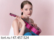 Musician holding ukulele, looking at camera with warm look. Young woman looks carefree and relaxed. Стоковое фото, фотограф А. А. Пирагис / Фотобанк Лори