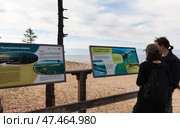 BAIKAL LAKE, KHUZHIR VILLAGE, IRKUTSK REGION, RUSSIA - August 03, 2024: Tourists study posters describing sights of Olkhon Island on ecological trail of Saraiskiy Bay on summer holiday. Редакционное фото, фотограф Виктория Катьянова / Фотобанк Лори