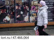 Женщина идет по Тверской улице на фоне фотографии празднования Дня Победы - 9 мая, в центре города Москвы, Россия. Редакционное фото, фотограф Николай Винокуров / Фотобанк Лори