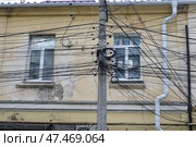 Спутанные провода на столбе у дореволюционного здания в центре городя Симферополя. Стоковое фото, фотограф Snezka / Фотобанк Лори