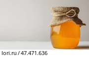 Homemade jam in a glass jar with a burlap cover on a clean white background. Домашнее варенье в стеклянной банке с рогожной крышкой на белом фоне. Стоковое AI-изображение, AI-художник Katsiaryna Repich / Фотобанк Лори