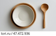 Bowls and wooden spoon arranged neatly on a clean surface. Миски и деревянная ложка аккуратно размещены на чистой поверхности. Стоковое AI-изображение, AI-художник Katsiaryna Repich / Фотобанк Лори