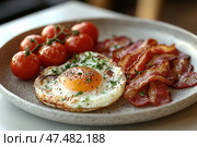 Fried eggs and bacon for breakfast in a gray ceramic plate on a table. Traditional American Breakfast with fried eggs, ham, fresh tomatoes and cress served in a diner. Keto diet. Стоковое AI-изображение, AI-художник Марина Демидюк / Фотобанк Лори
