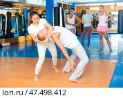 Young latina performing inverted headlock during self defence training. Стоковое фото, фотограф Яков Филимонов / Фотобанк Лори
